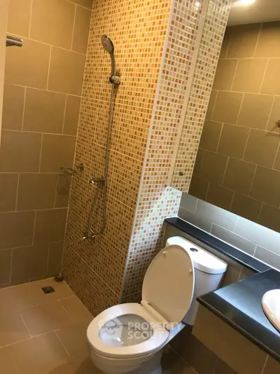 Modern bathroom with tiled shower and sleek fixtures in a contemporary apartment.