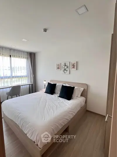 Modern bedroom with stylish decor and natural light, featuring a comfortable bed and elegant furnishings.