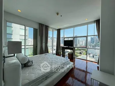 Luxurious bedroom with stunning city view and modern furnishings in high-rise apartment.