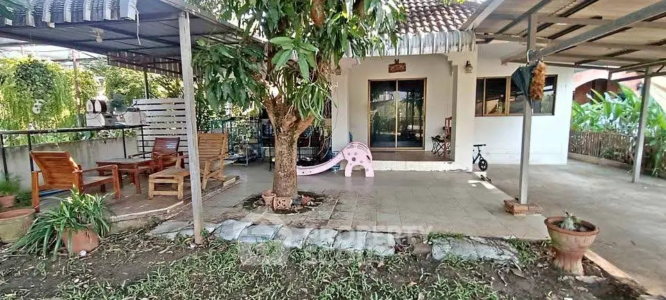 Charming outdoor patio with seating area and garden, perfect for relaxation and family gatherings.