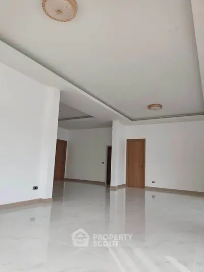 Spacious modern living room with high ceilings and elegant tile flooring, perfect for luxury living.