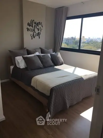 Cozy bedroom with large window and stylish decor in modern apartment