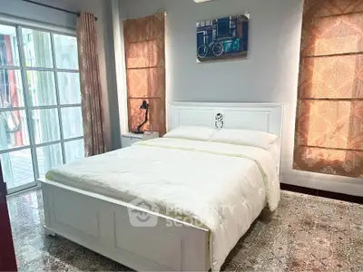Cozy bedroom with elegant decor and large windows for natural light