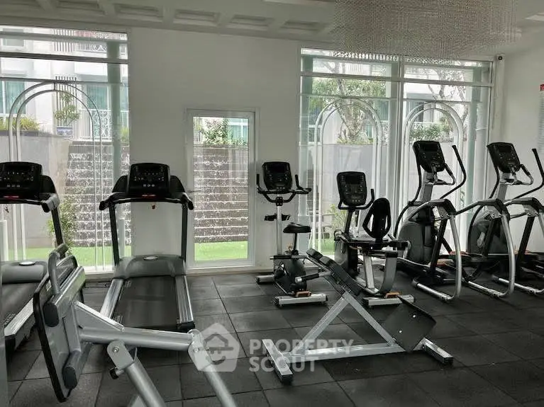 Modern gym with state-of-the-art equipment and large windows for natural light.