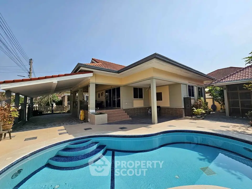 Stunning villa with private pool and spacious outdoor area under clear blue sky.
