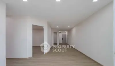 Spacious modern hallway with wooden flooring and recessed lighting