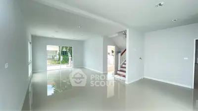 Spacious open-plan living area with glossy floors and large windows in modern home