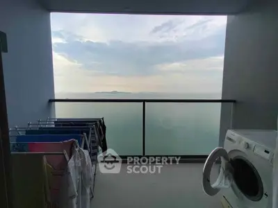 Stunning ocean view from balcony with laundry area and washing machine.
