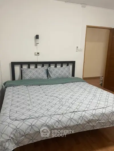 Cozy bedroom with modern decor and comfortable bedding in a stylish apartment.