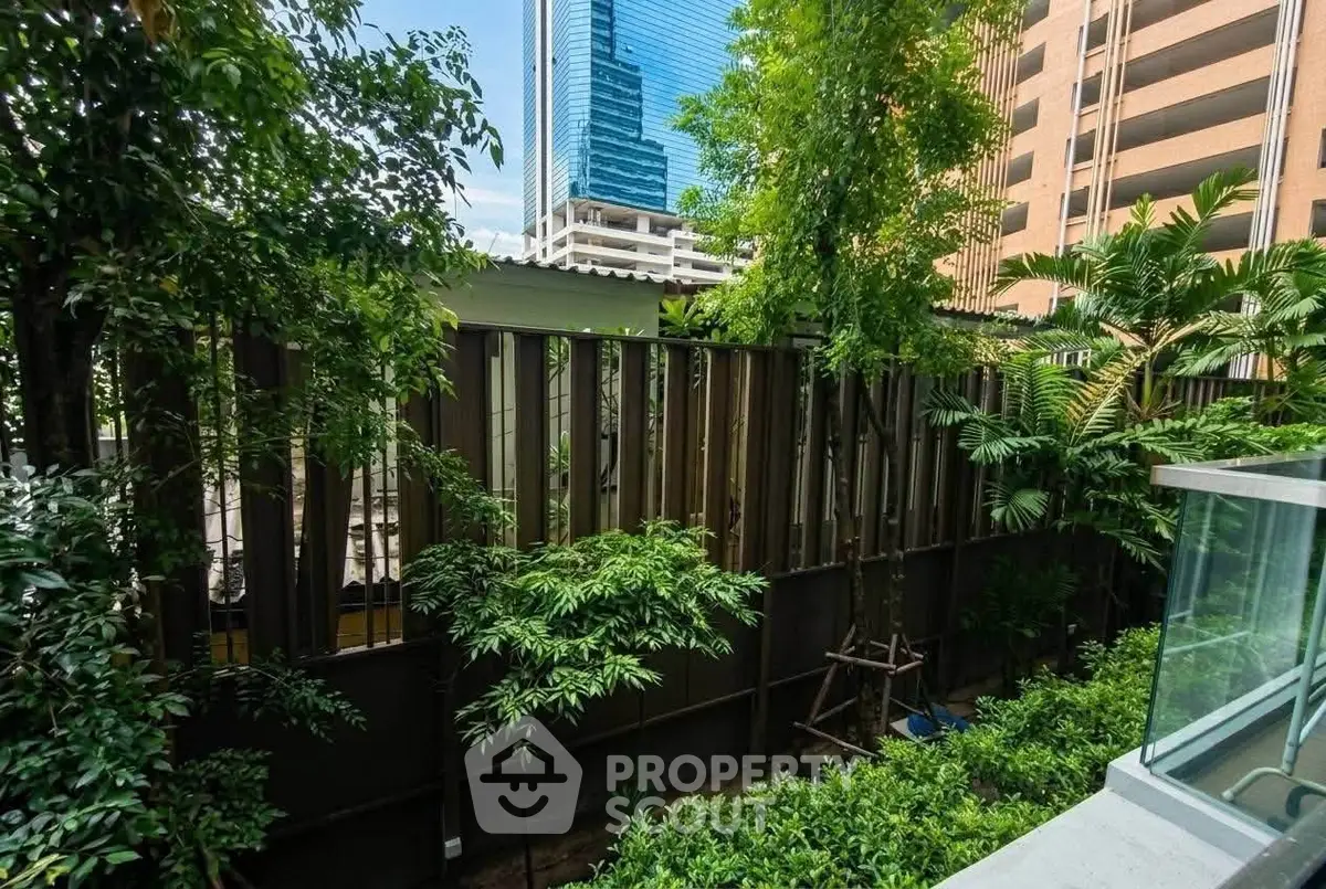 Lush garden view from a modern apartment balcony with cityscape backdrop.