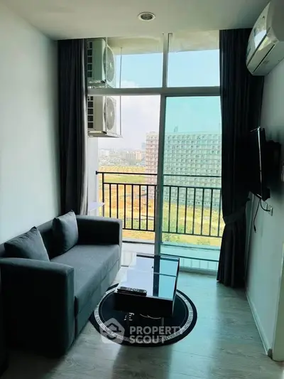 Modern living room with large window and city view, featuring a sleek sofa and wall-mounted TV.