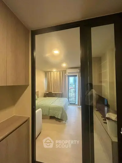 Modern bedroom with sliding glass doors and balcony access in a stylish apartment.