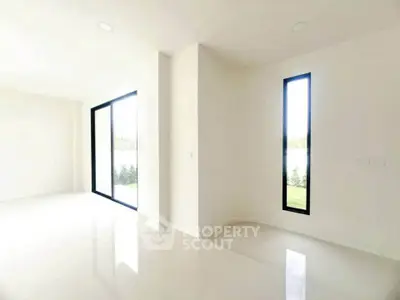 Spacious modern interior with large windows and glossy floors, offering abundant natural light and serene views.