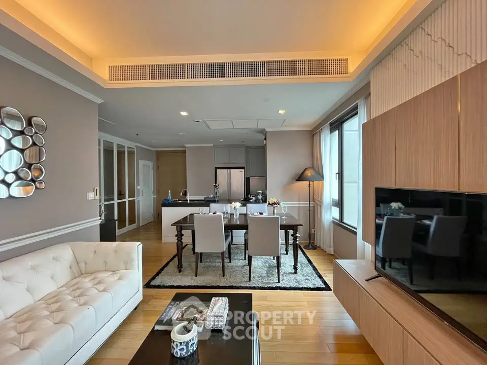 Luxurious open-plan living room with modern kitchen and elegant dining area, featuring stylish decor and ample natural light.
