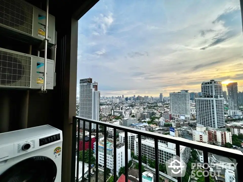 Stunning high-rise city view from balcony with washing machine and air conditioning units.