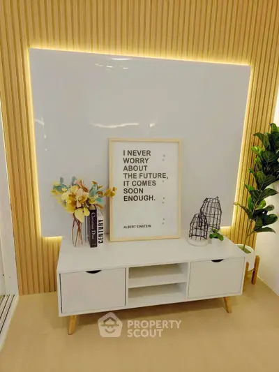Modern living room with stylish decor and motivational quote, featuring sleek white console and ambient lighting.