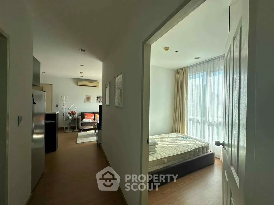 Modern apartment interior with bedroom and living area, featuring natural light and stylish decor.