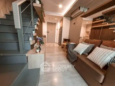 Modern living room with stylish staircase and cozy seating area in a contemporary apartment.