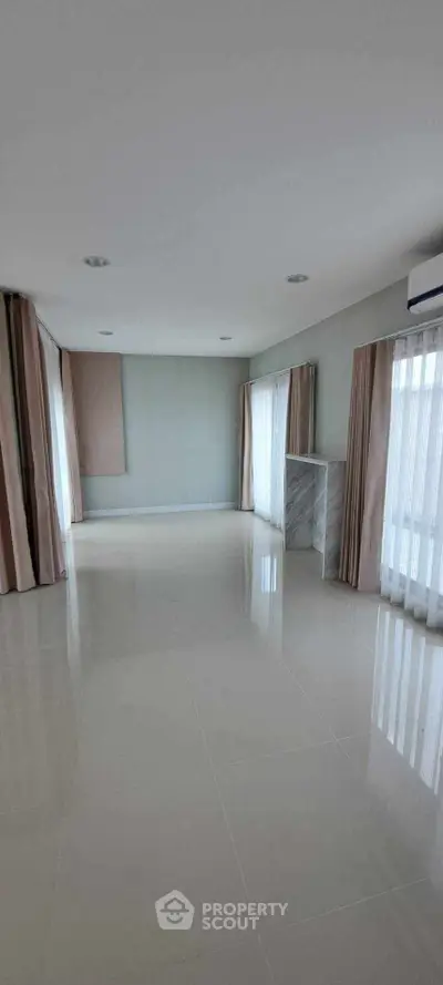 Spacious empty room with large windows and elegant curtains, perfect for customization.