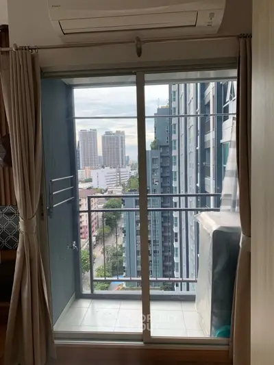 Modern apartment balcony with city view, featuring sliding glass doors and air conditioning unit.