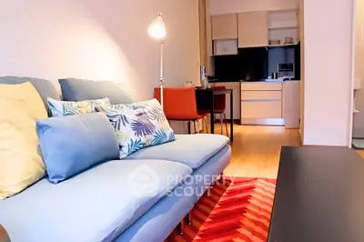 Modern living room with cozy sofa and stylish kitchen in open layout apartment.