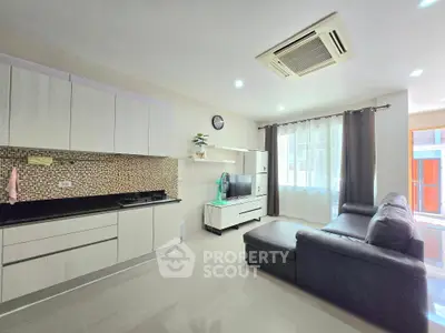 Modern living room with sleek kitchen and cozy seating area