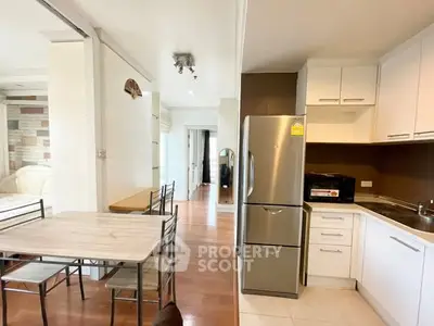 Modern kitchen and dining area with stainless steel appliances and wooden flooring