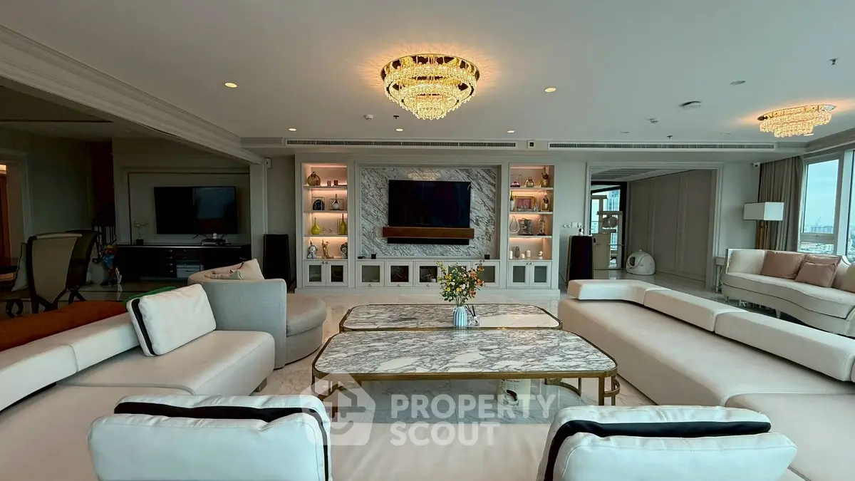 Luxurious and spacious living room with elegant chandeliers and marble coffee tables.