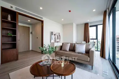 Modern living room with stylish furniture and large windows offering city views.