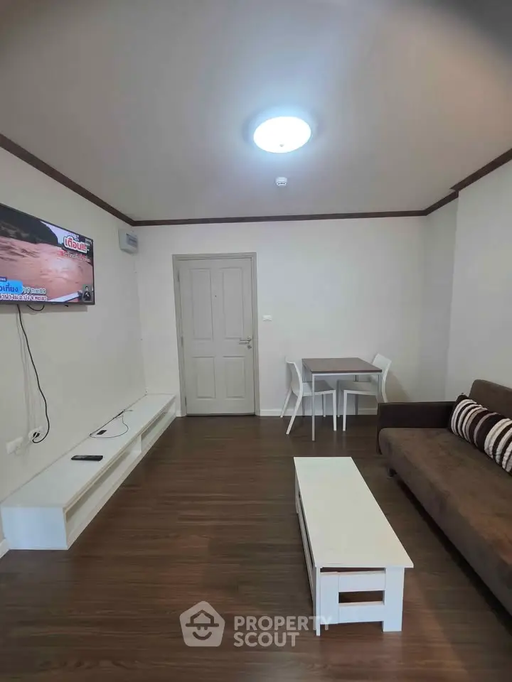 Modern living room with sleek furniture and mounted TV, perfect for relaxation.