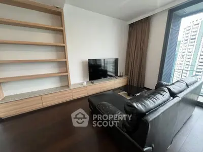 Modern living room with sleek leather sofa and built-in shelving, offering a cozy urban view.
