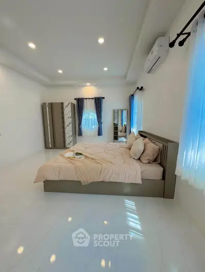 Spacious bedroom with modern decor and natural light