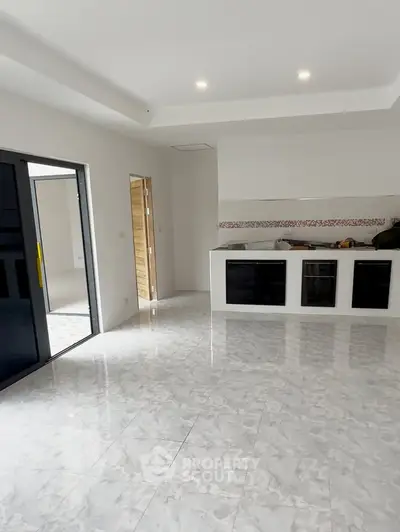 Spacious modern kitchen with sleek marble flooring and open layout design.