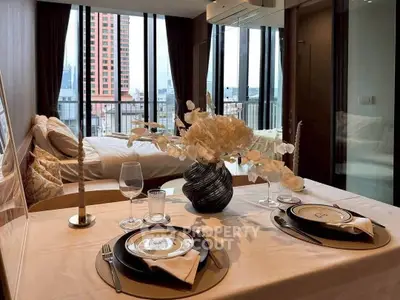 Luxurious bedroom with elegant dining setup and stunning city view from balcony.