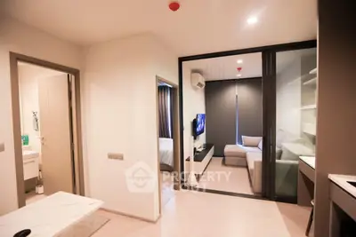 Modern apartment interior with open living room and bedroom, featuring sleek design and neutral tones.
