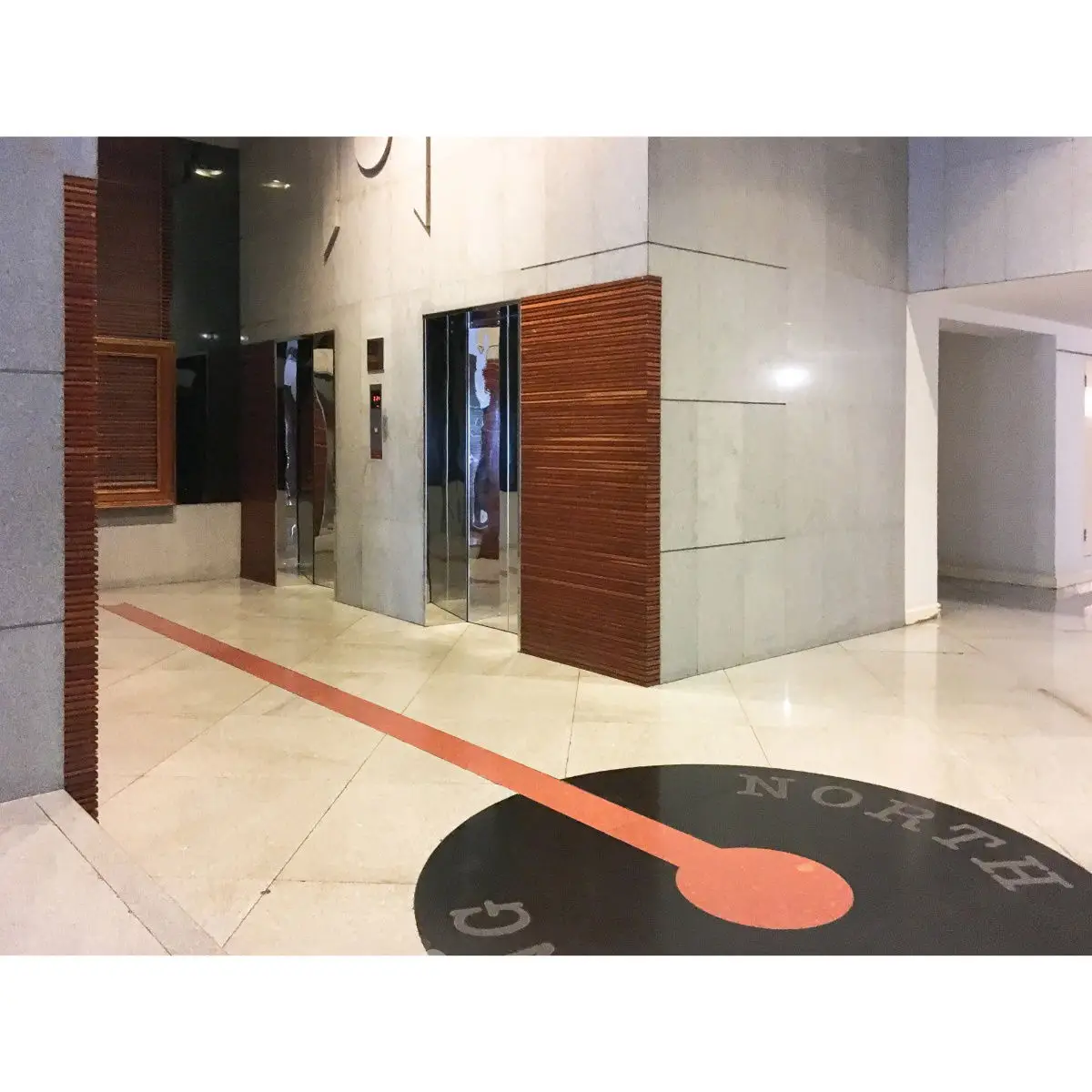 Modern building entrance with sleek elevator design and polished stone flooring.