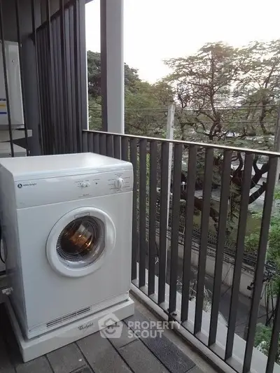 Spacious balcony with washing machine and scenic view, perfect for urban living.