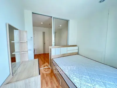 Modern bedroom with wooden furniture and large window for natural light.