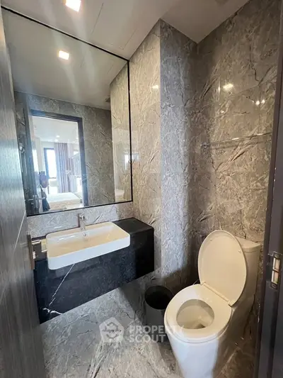 Luxurious marble bathroom with modern fixtures and large mirror