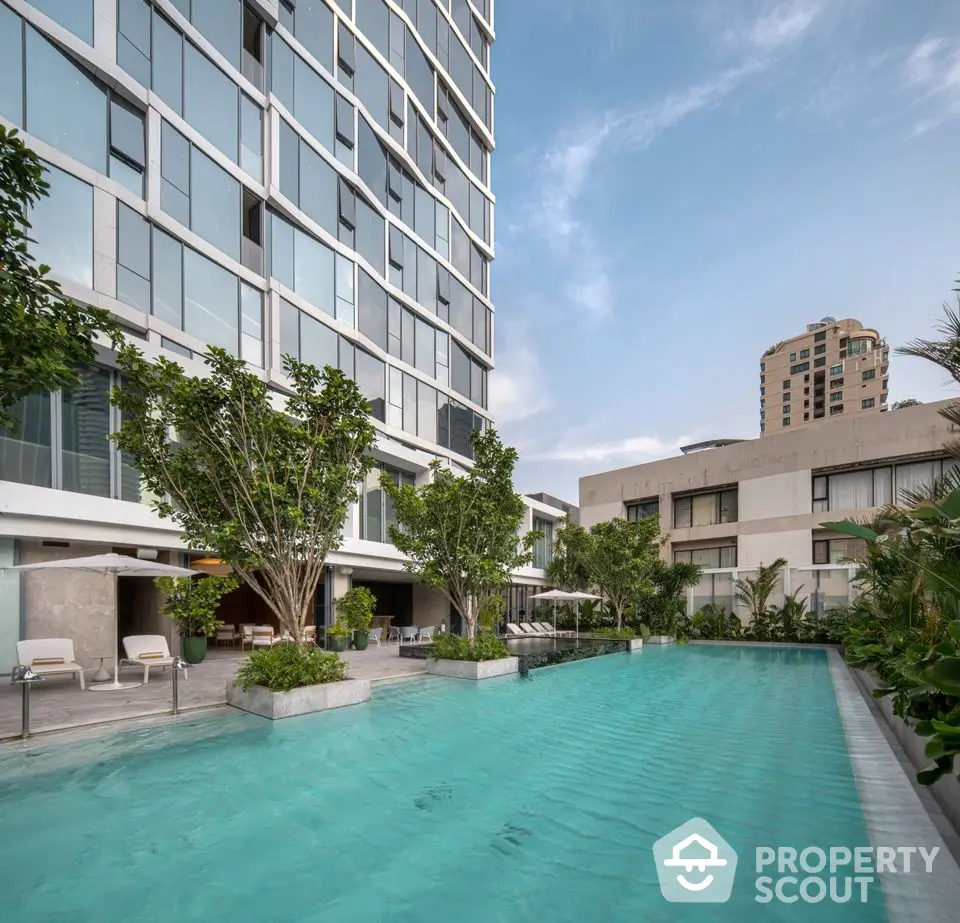 Luxurious residential building with stunning pool and lush greenery, perfect for modern living.