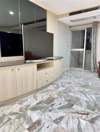 Spacious living room with modern TV setup and elegant marble flooring