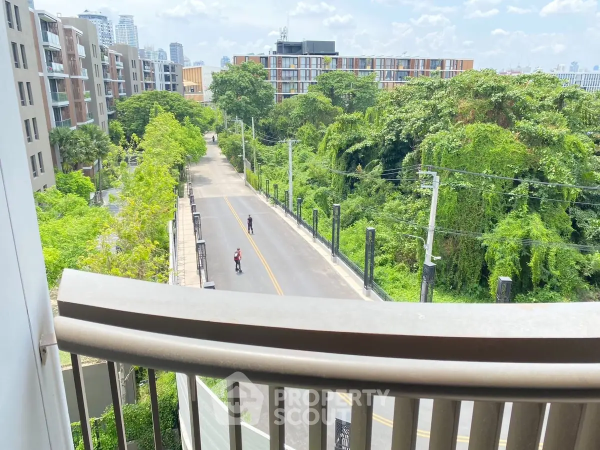 Stunning balcony view overlooking lush greenery and modern urban landscape.