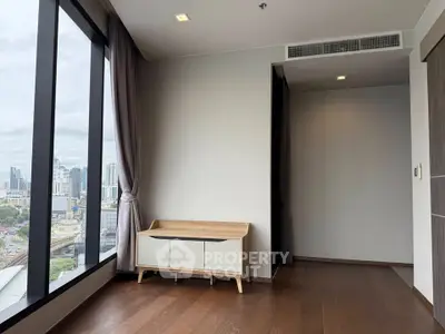 Modern apartment with large windows offering stunning city views and elegant wooden flooring.