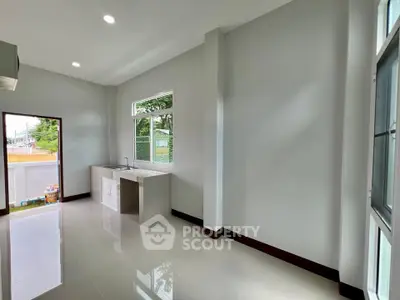 Spacious modern kitchen with sleek countertops and large windows for natural light.