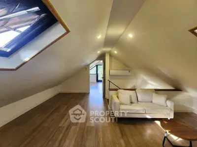 Spacious attic living room with skylight and modern decor