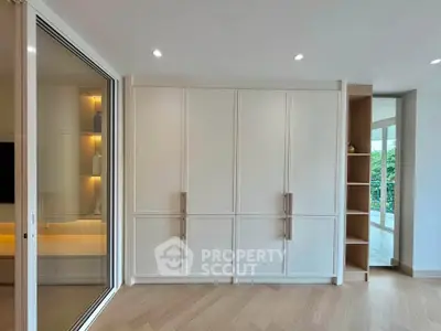 Spacious modern living room with elegant built-in storage and large windows for natural light.