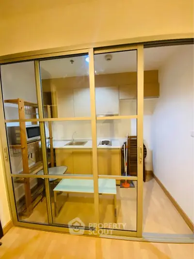 Modern compact kitchen with sliding glass doors and wooden flooring