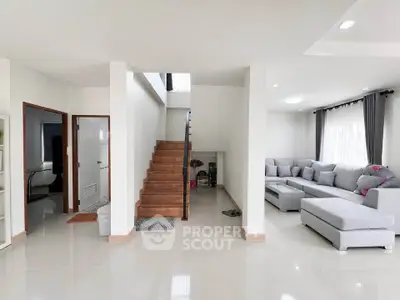 Spacious modern living room with elegant staircase and cozy sectional sofa