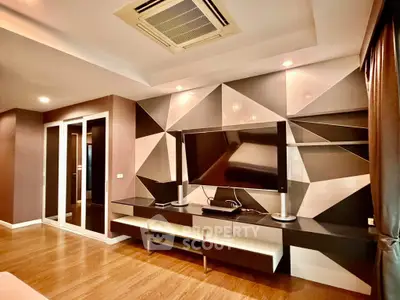 Modern living room with geometric wall design and large TV unit