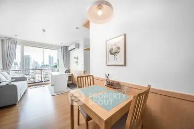 Bright modern living room with city view, featuring dining area and cozy seating.